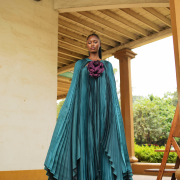 Fabric Elegant teal pleated cape gown with bold floral appliqué